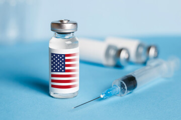 American vaccine concept. Ampoule with injection from covid-19 on a blue background and a syringe
