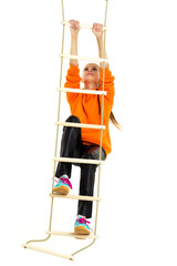 Sportive teen girl playing on rope ladder