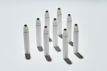 Many tubes for eye roller beauty product isolated over white background with reflection