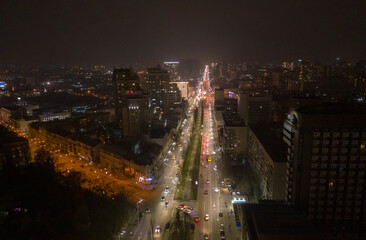 Fototapeta na wymiar Aerial view of night streets in downtown Kyiv, Ukraine, with bright night illumination. Wide shot with smooth cinematic drone motion. 4k hyperlapse footage