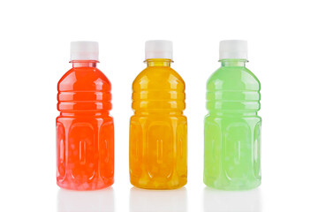 Three plastic bottles with fruit drink of different colors isolated on white