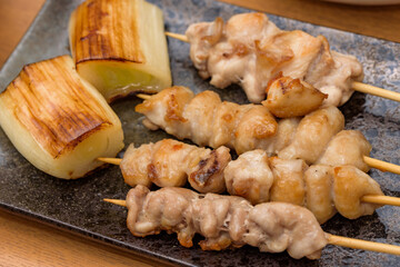 skewered chicken and green onions on a plate, Yakitori