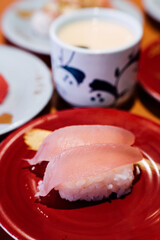 Sushi and Sashimi. Dishes of Sushi and Sashimi rolling on conveyer belt.
