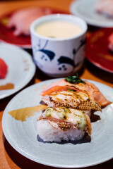Sushi and Sashimi. Dishes of Sushi and Sashimi rolling on conveyer belt.