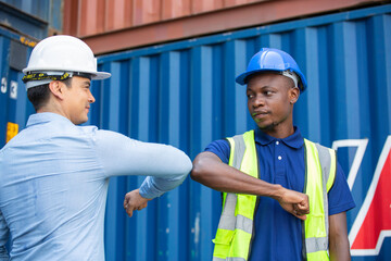 construction site worker and foreman elbow bump greeting in New Normal adaptation to prevent...