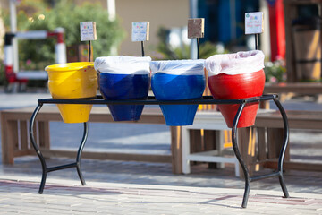 Clay pots of different colors with tables Paper, Plastic, Metal. Garbage sorting in one hotel of Egypt.