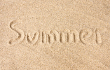 Summer text on sand under sunlight