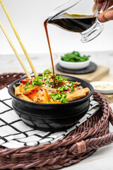 Asian salad with rice noodles, vegetables, mushrooms, chicken and soy sauce. Funchose with white transparent noodles in black plate