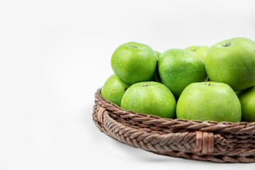 Group of ripe green apples in a basket on white background