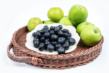 Summer harvest of fresh ripe blueberries and green apples in a basket