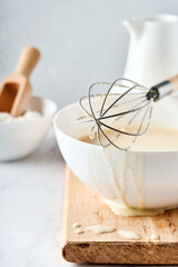 Preparation of dough for home pancakes for Breakfast or for Maslenitsa. Ingredients on the table - wheat flour, eggs, butter, sugar, salt, milk. Recipe step by step. Selective focus.