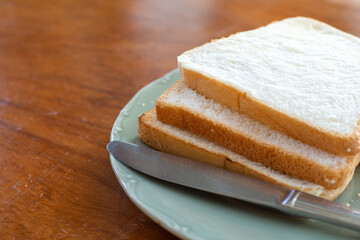 Slice bread stacked together with knives on a plate.