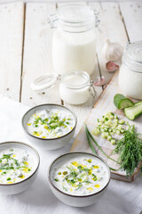 Traditional summer cold soup of homemade yogurt, cucumbers and fresh herbs on a table
