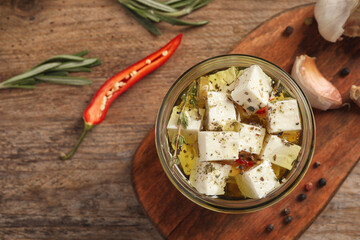 Flat lay composition with marinated feta on wooden table