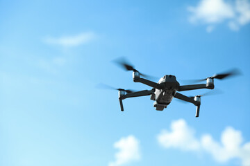 Fototapeta na wymiar Modern drone with camera flying in sky on sunny day