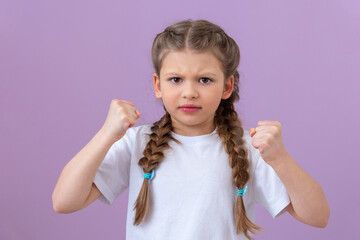 Little schoolgirl shows two fists. Isolated background.