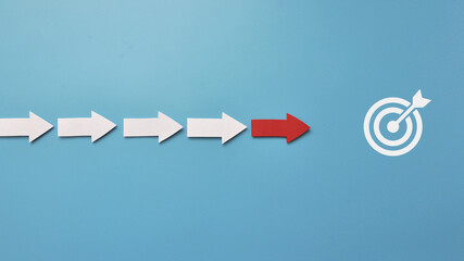Many white arrows follow one red arrow. Symbol of following the leader straight to the goal