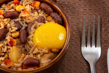 rice and beans with egg on dark wooden table