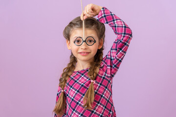 A small child tried on masquerade glasses.