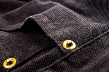 clothing items stonewashed cotton fabric texture with seams, clasps, buttons and rivets, macro