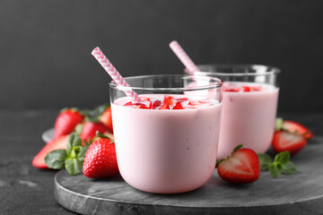 Delicious drink with strawberries on black table