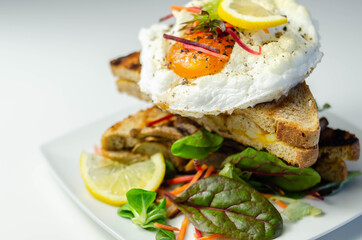Egg in a cloud on grilled sandwiches with cumberland sausage, tomato and mayonnaise, all served with a fresh salad