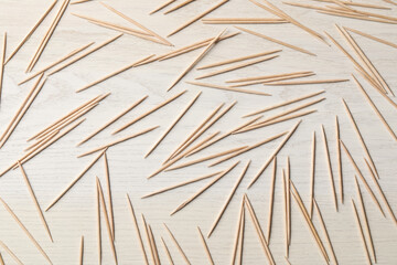 Disposable toothpicks on white wooden background, flat lay