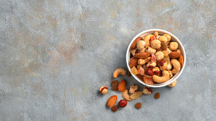Mixed nuts and dried fruits on a gray background. Top view, copy space.