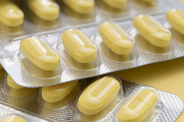 Macro shot of yellow pills on yellow background