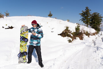 A man standing by a snowboard