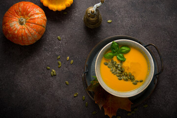 Hot autumn pumpkin soup with pumpkin seeds, copy space