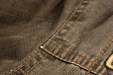 clothing items stonewashed cotton fabric texture with seams, clasps, buttons and rivets, macro