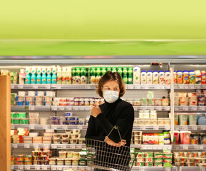 Supermarket shopping, face mask and gloves,Young man shopping in supermarket, reading product information