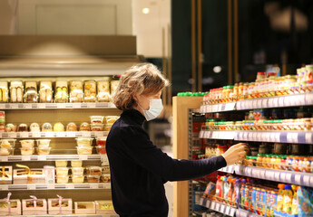 Supermarket shopping, face mask and gloves,Young man shopping in supermarket, reading product information