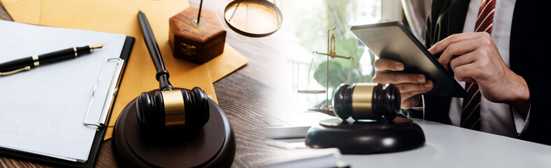 Justice and law concept.Male judge in a courtroom with the gavel, working with, computer and docking keyboard, eyeglasses, on table in morning light