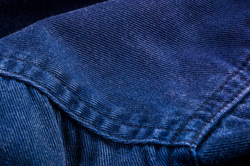 clothing items stonewashed cotton fabric texture with seams, clasps, buttons and rivets, macro