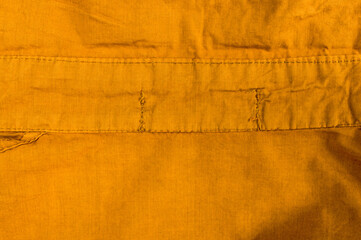 clothing items stonewashed cotton fabric texture with seams, clasps, buttons and rivets, macro