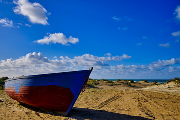 Wooden boat in the sand close to the beach