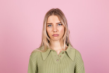 Pretty european woman in casual sweater on pink background suffering unhappy  with gloomy...