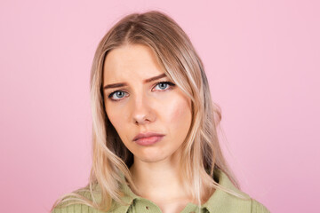 Pretty european woman in casual sweater on pink background suffering unhappy  with gloomy...