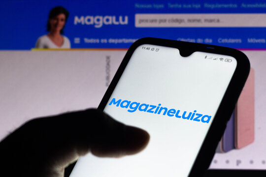 April 15, 2021, Brazil. In this photo illustration the Magazine Luiza logo seen displayed on a smartphone screen with the logo of Magalu in the background.