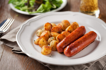 Sausages and potatoes on a plate. High quality photo.