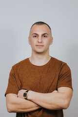 Handsome Caucasian male posing with crossed arms against a white wall