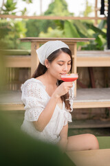 Beautiful young asian woman drinking mixed berry mocktail in the cafe