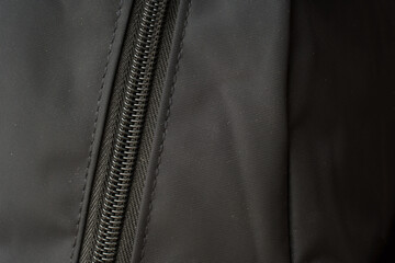 zipper on black material fabric. close-up of a snake fastener