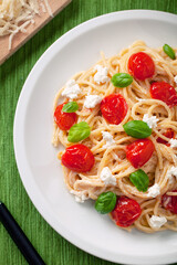 Spaghetti with cherry tomatoes and fresh ricotta on a plate.