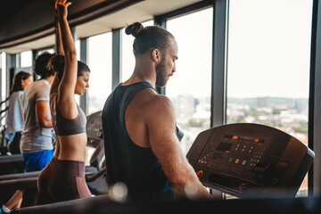 Group of young people running on treadmills in sport gym