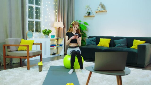 A Girl Is Sitting On A Yellow Yoga Ball And She Is Wearing A Yellow Headset, She Is About To Workout And She S Listening To Music, She S In A Room That Has Yellow Coordinated Things