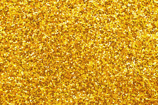 glittering background of golden sequins closeup. Sparkle festive texture