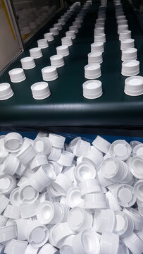 White Plastic bottle caps, made from injection molding machine. in  production department of the plastic factory.